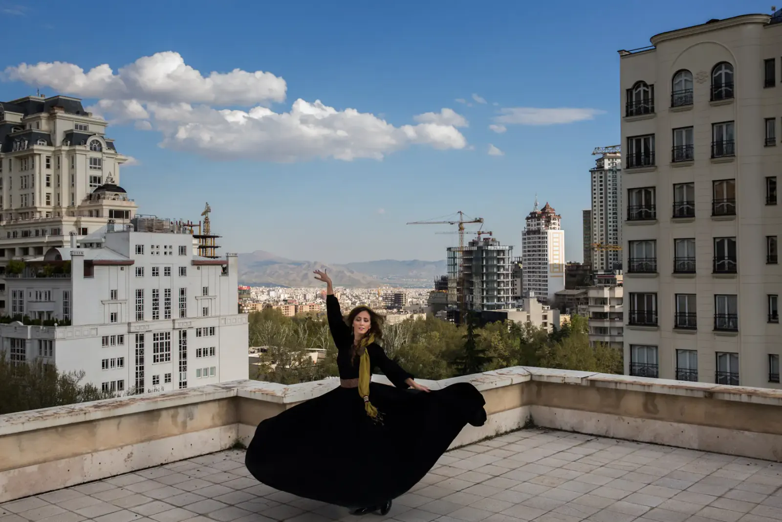 Banafsheh Amiri dancing in black on a Tehran rooftop